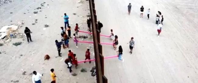 Le altalene rosa che abbattono le divisioni, installate per i bambini nel muro tra Messico e USA